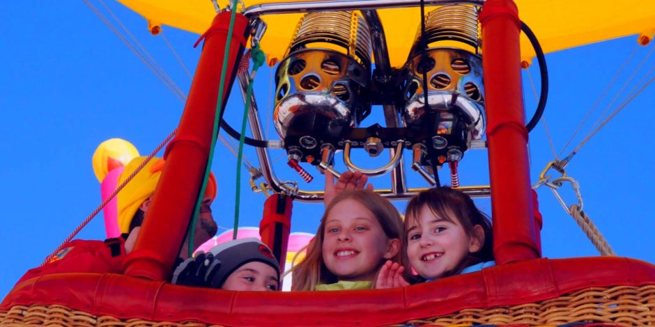 three kids riding hot air balloon